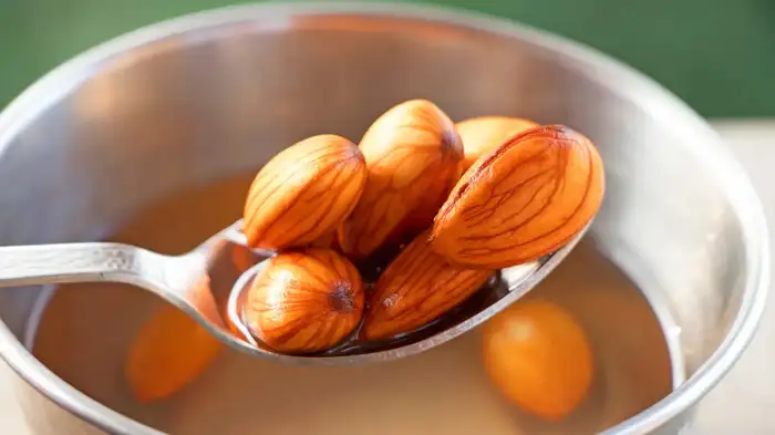 soaked almonds in water on spoon soaked almonds in water on spoon