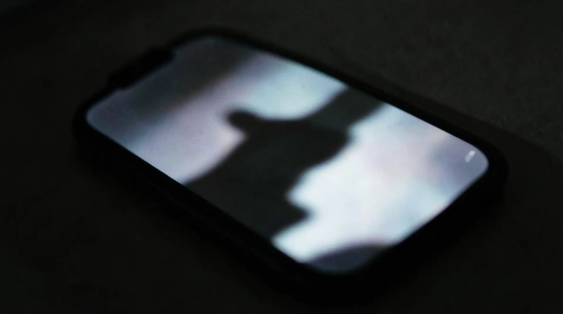 Shadowed Hand on Glowing Screen
