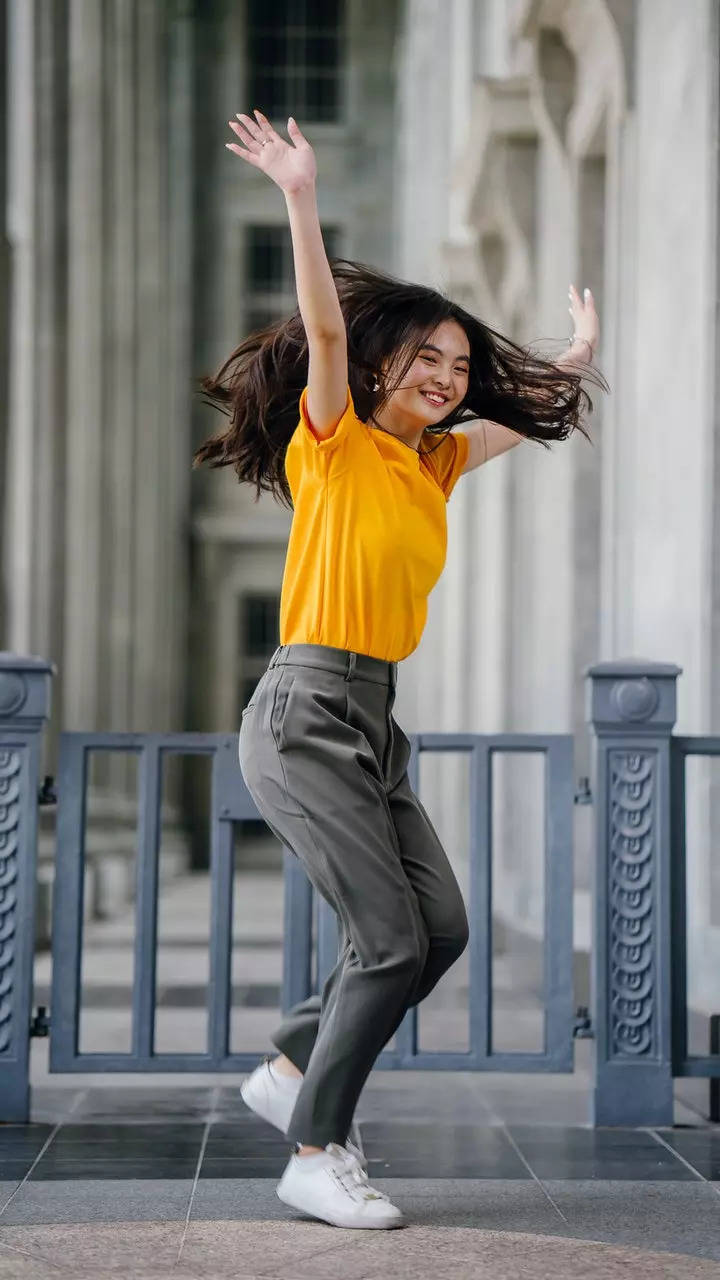 A woman in a yellow shirt and grey pants photo  Woman Image on Unsplash