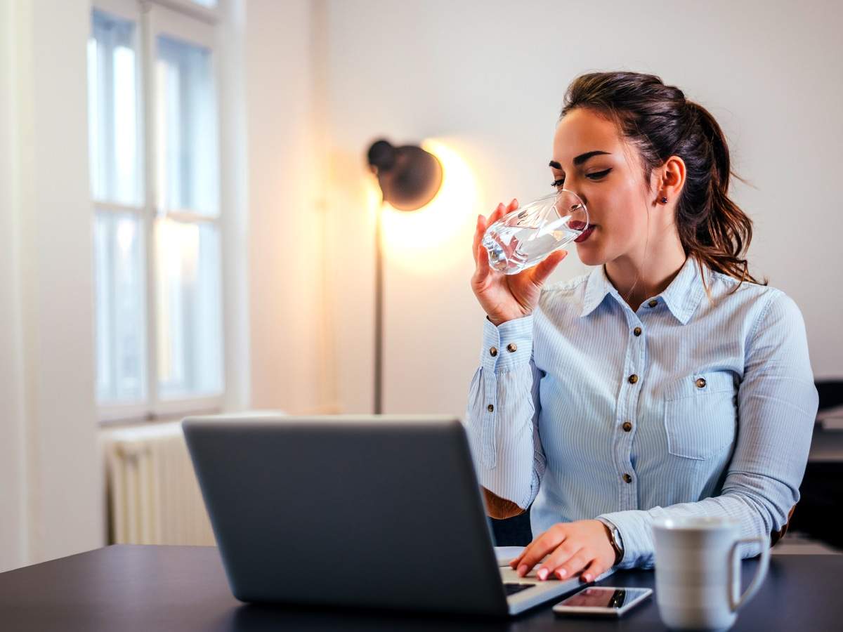 Working and drinking. Стакан воды в офисе. Вода в офисе. Девушка пьет воду в офисе. Девушка со стаканом воды.