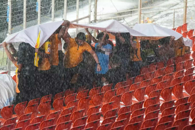Fans protecting themselves from getting wet with their posts and banners 