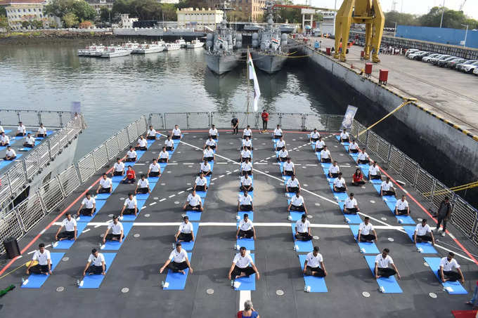 नौदल गोदीत उभ्या असलेल्या आयएनएस मोरमुगाव व आयएनएस विशाखापट्टणम वर नौदल कर्मचारी योगासने करताना
