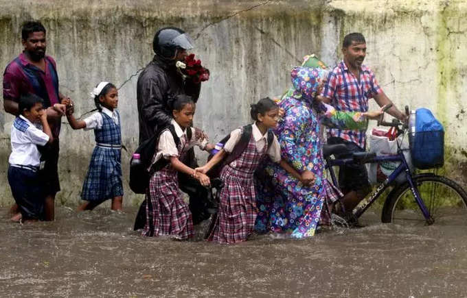 पावसाच्या साठलेल्या पाण्यात  कॅमेरा घेऊन जाण्याचे धाडस करणारा हा फोटोग्राफर