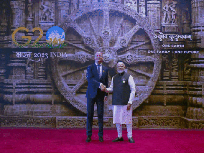 प्रधानमंत्री नरेंद्र मोदी इस समय भारत मंडपम में G20 शिखर सम्मेलन में पहुंचने वाले विदेशी नेताओं का स्वागत कर रहे हैं। बैकग्राउंड में कोणार्क मंदिर का सूर्य चक्र है जिसे भारत ने अपने राष्‍ट्रध्‍वज में लिया है।