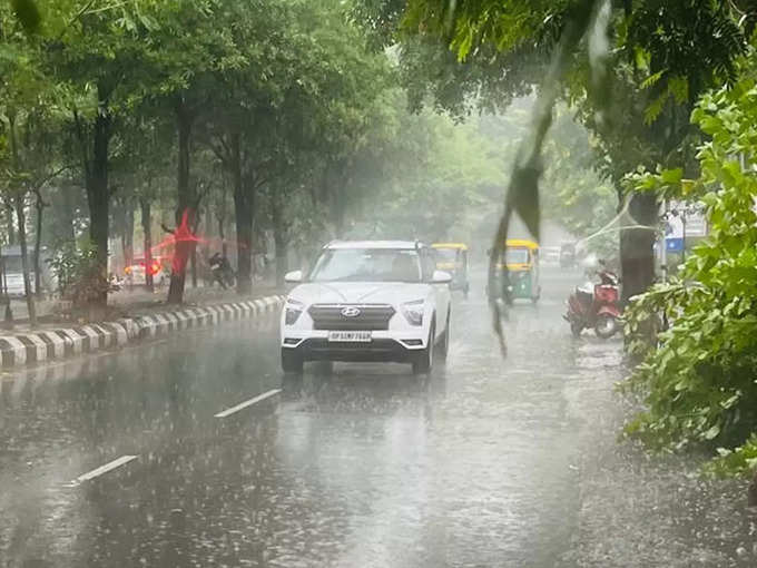 लखनऊ में सोमवार को बारिश के बीच गुजरती कार