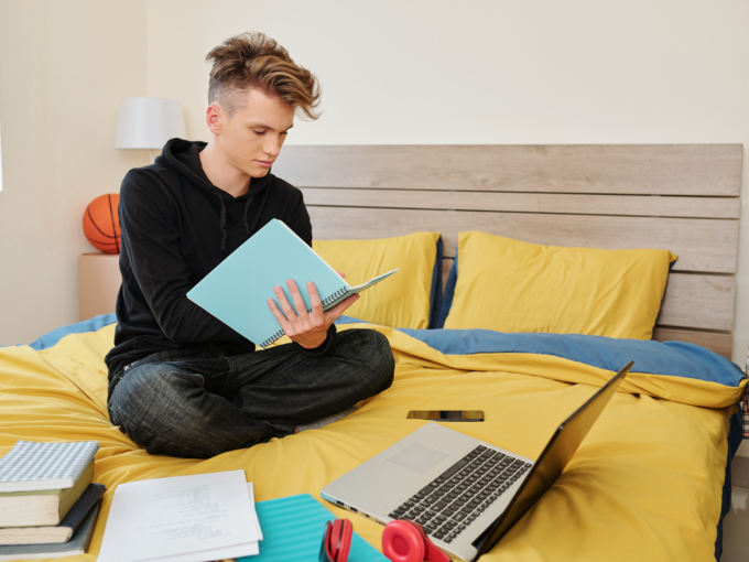 teenager boy child study exam on bed