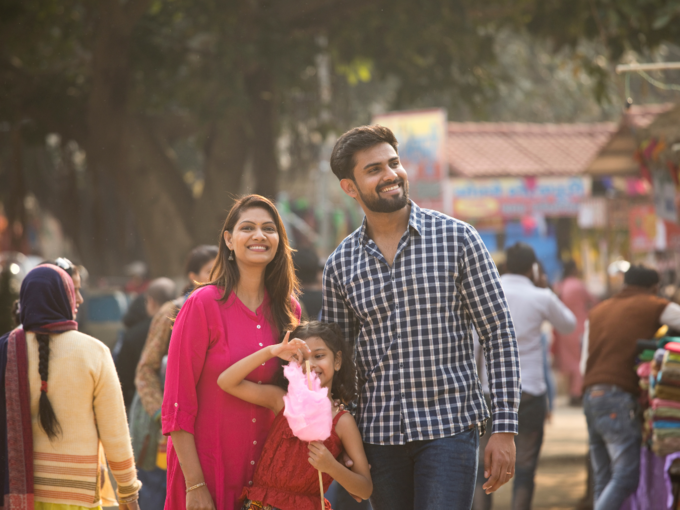 family outing couple woman man kid girl cotton candy