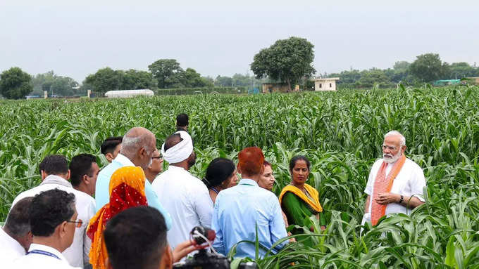 రైతులతో మోదీ ముచ్చట్లు.. వర్షంలో గొడుగు పట్టుకున్న ప్రధాని