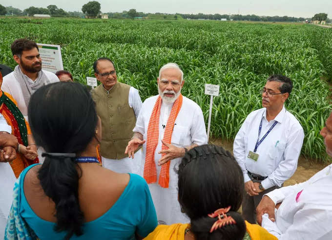 రైతులతో మోదీ ముచ్చట్లు.. వర్షంలో గొడుగు పట్టుకున్న ప్రధాని