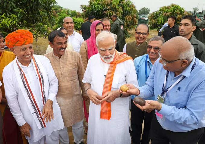 రైతులతో మోదీ ముచ్చట్లు.. వర్షంలో గొడుగు పట్టుకున్న ప్రధాని