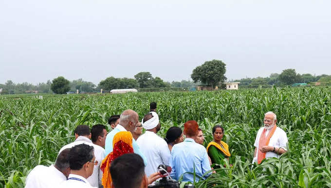 రైతులతో మోదీ ముచ్చట్లు.. వర్షంలో గొడుగు పట్టుకున్న ప్రధాని