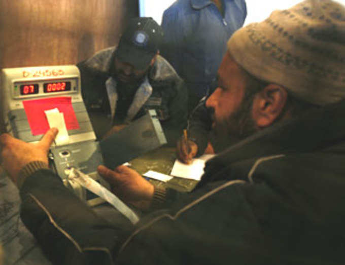 Kashmiri officials count votes on an electronic voting machine in Srinagar
