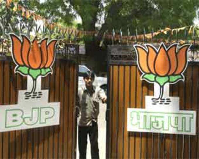 A man closes the gates leading to the central office of the Bharatiya Janata Party headquarters in New Delhi