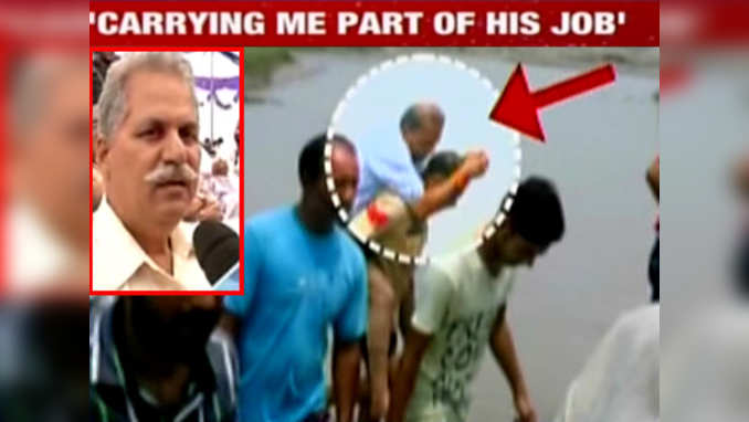 Security guard carries MLA on back while crossing stream