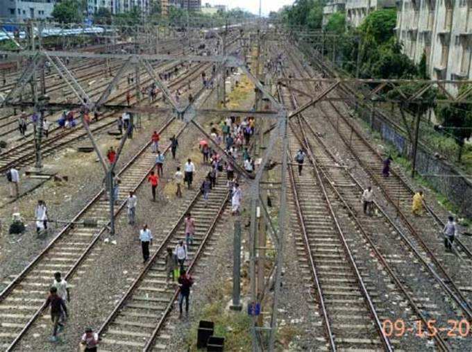 मुंबई: पश्चिम रेल्वेवरील वाहतूक ठप्प झाल्याने रेल्वे रुळांतून पायपीट करणारे प्रवासी.