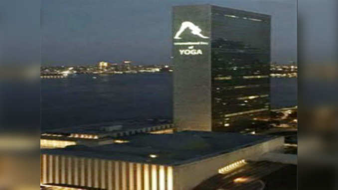 UN headquarters lit up with gigantic human figure in yoga posture 