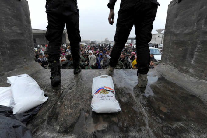 Russian soldiers distribute food aid to rescued civilians