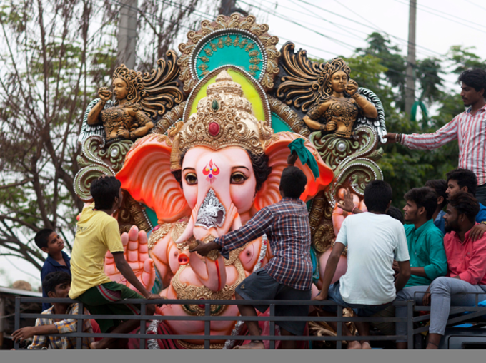 भव्य गणेश प्रतिमा ले जाते भक्त