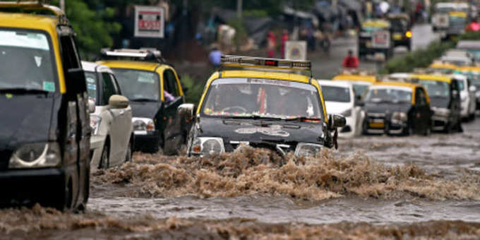 देखें, बारिश के कारण सड़क पर हुए जलभराव के बीच गुजरती गाड़ियां
