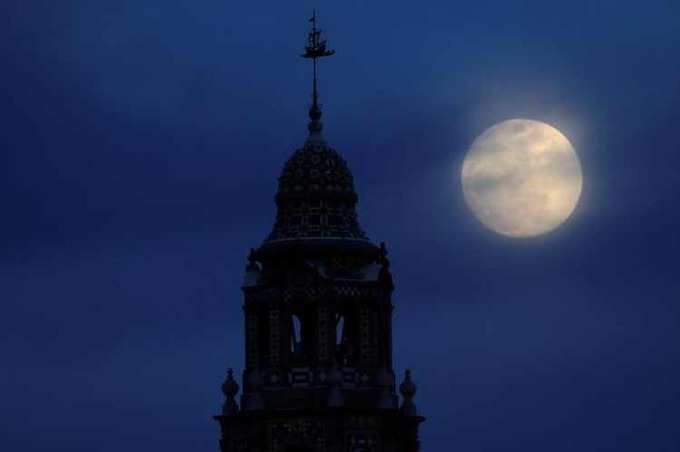 A blue moon rises over Balboa Parks California Tower in