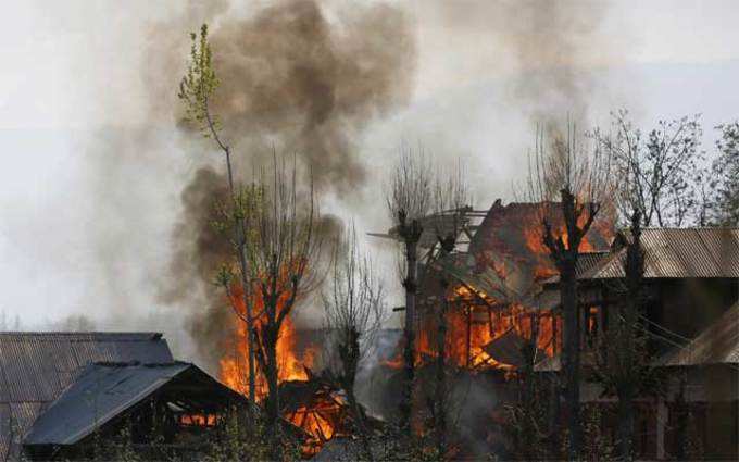 मुठभेड़ के दौरान एक घर में लगी आग।