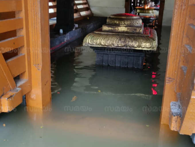 കനത്ത മഴയിൽ ശ്രീകോവിൽ വെള്ളത്തിലായി; ഓട്ടുരുളി &#39;തോണി&#39;യാക്കി പൂജാരി