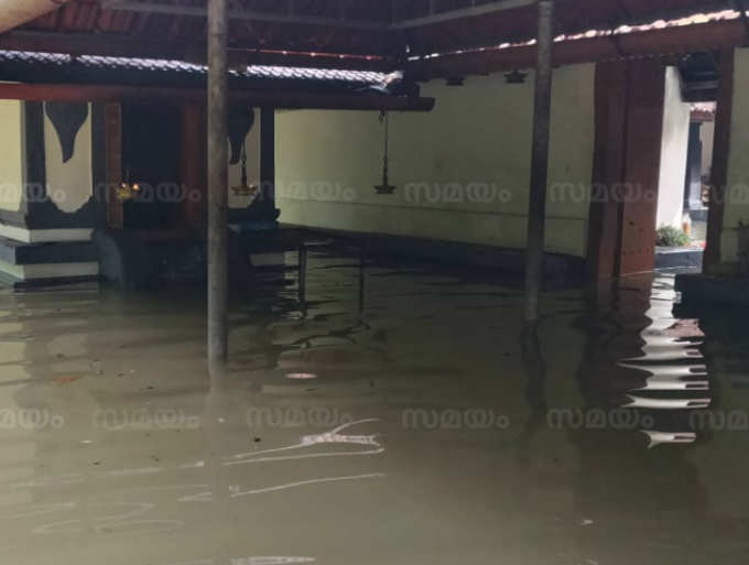 കനത്ത മഴയിൽ ശ്രീകോവിൽ വെള്ളത്തിലായി; ഓട്ടുരുളി &#39;തോണി&#39;യാക്കി പൂജാരി