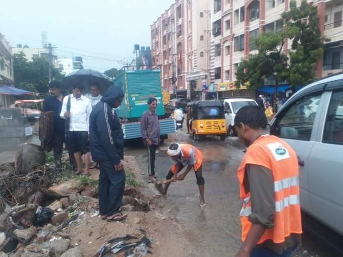 వర్షపు నీటిని తొలగించే పనిలో జీహెచ్‌ఎంసీ సిబ్బంది.