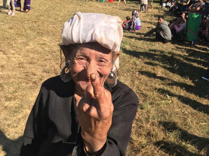 मिजोरम में मतदान करने के बाद उंगली पर लगी स्याही दिखातीं एक बुजुर्ग मतदाता।
