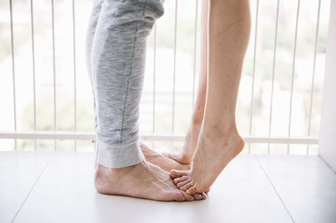 young-woman-standing-man-feet-kissing_23-2147992173