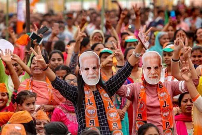 Kathua: BJP supporters wear masks of Prime Minister Narendra Modi at an election...