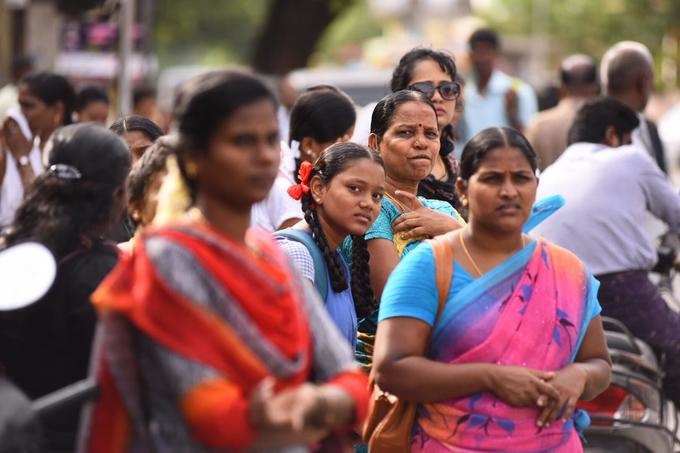 பேருந்துக்காக காத்திருக்கும் மாணவா்கள், பயணிகள்