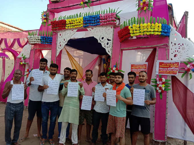 दुर्गा पंडाल के बाहर पोस्‍टर लेकर खड़े कमिटी सदस्‍य