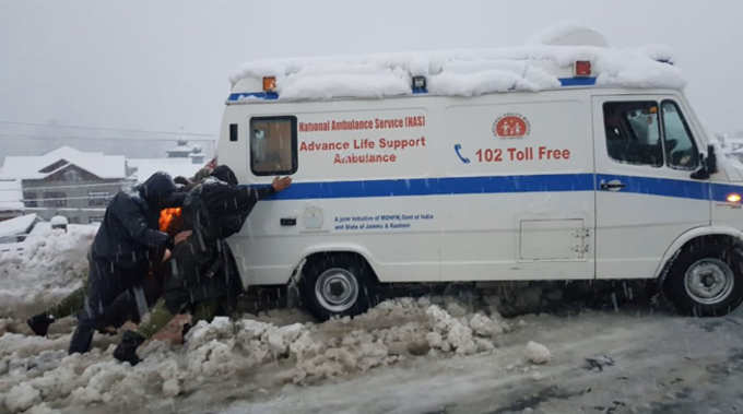 बर्फ में फंसी ऐंबुलेंस को निकालते पुलिसकर्मी