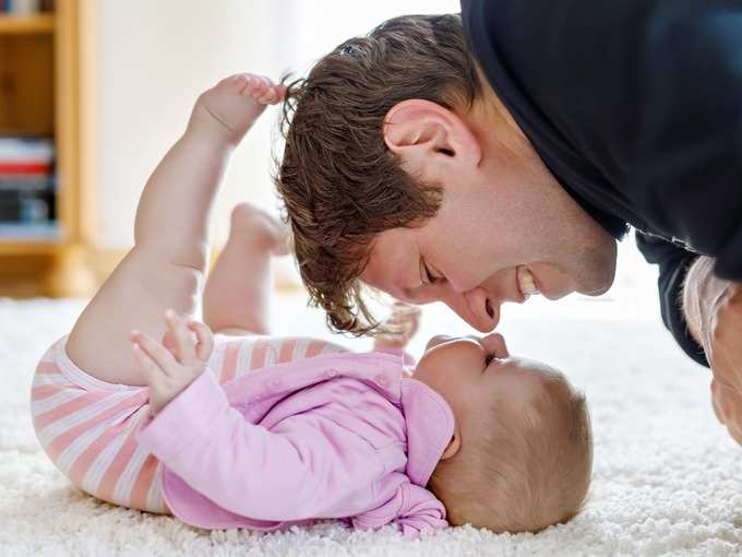 Father plays with newborn baby