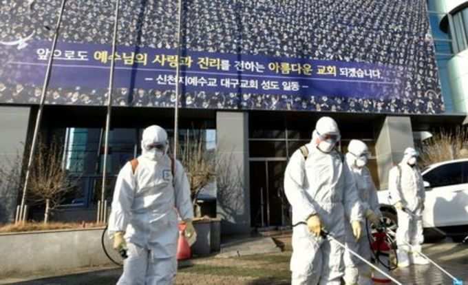 Workers from a disinfection service company sanitize a street in front of a branch of the Shincheonji Church of Jesus the Temple of the Tabernacle of the Testimony where a woman known as Patient 31 attended a service in Daegu