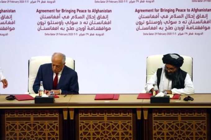 Mullah Abdul Ghani Baradar, the leader of the Taliban delegation, signs an agreement with Zalmay Khalilzad, U.S. envoy for peace in Afghanistan, at a signing agreement ceremony between members of Afghanistan&#39;s Taliban and the U.S. in Doha