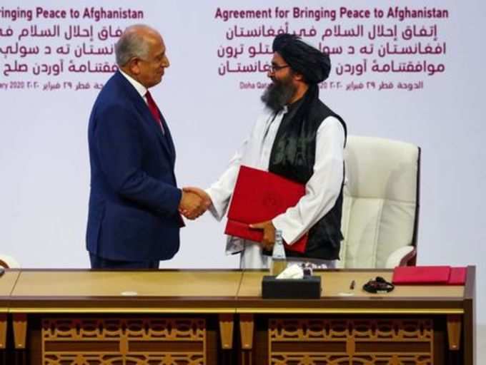 Mullah Abdul Ghani Baradar, the leader of the Taliban delegation, and Zalmay Khalilzad, U.S. envoy for peace in Afghanistan, shake hands after signing an agreement at a ceremony between members of Afghanistan&#39;s Taliban and the U.S. in Doha