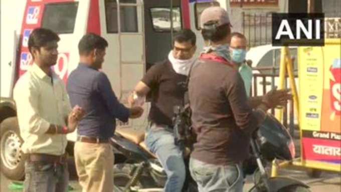 जनता कर्फ्यूः पटना में पुलिसकर्मियं को सैनिटाइजर और मास्क दे रहे लोकल लोग