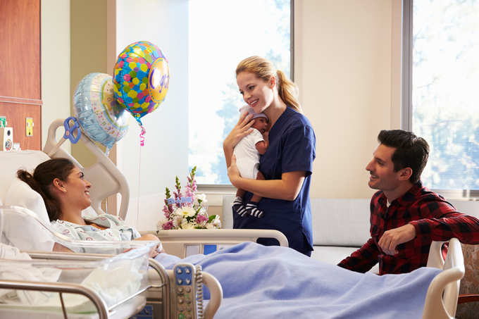 Family And Nurse With New Born Baby