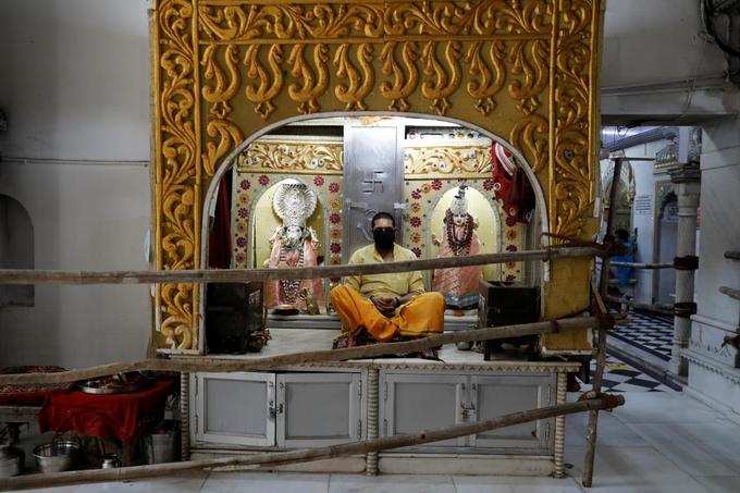 दिल्‍ली: मास्‍क पहनकर बैठे पुजारी जी