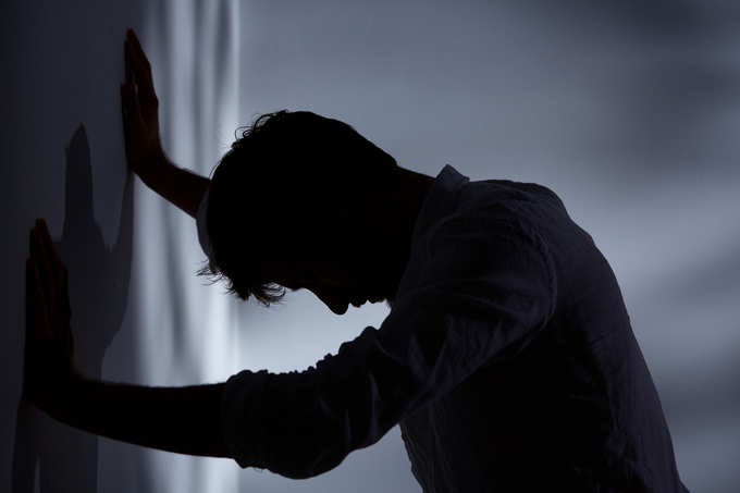 Man leaning hands against wall