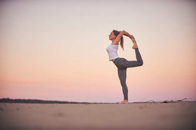 woman practices yoga asana Natarajasana