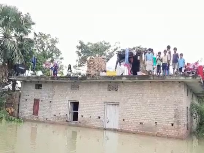 बाढ़ के पानी में फंसे बच्चे छत से लगा रहे गुहार