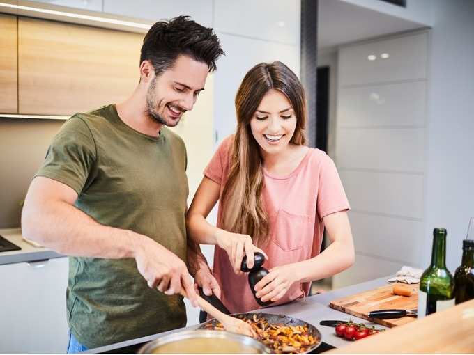cute-joyful-couple-cooking-together-and-adding-spice-to-meal-laughing-picture-id996097046 (1)