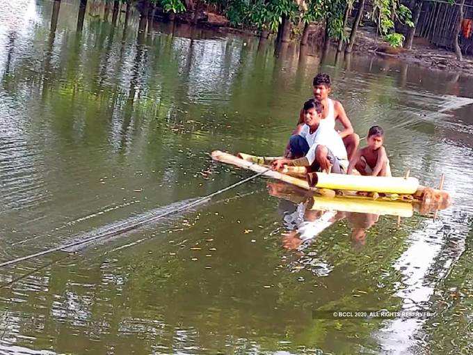 വെള്ളക്കെട്ട് മറികടക്കുന്ന ഗ്രാമവാസികൾ