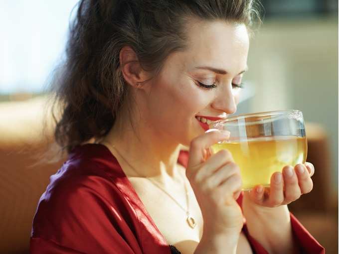 happy-woman-in-modern-house-in-sunny-day-drinking-cup-of-tea-picture-id1211579606