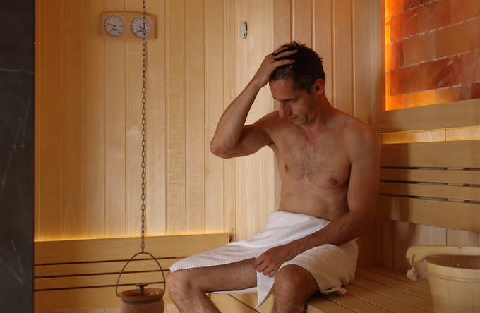 Muscular Man relaxing in sauna after workout. Relax concept stock photo