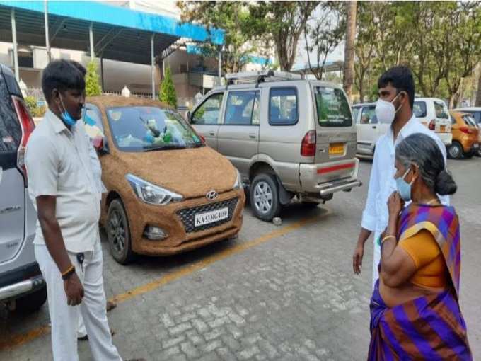 ఆవు పేడ పూసిన కారును ఆశ్చర్యంగా చూస్తున్న భక్తులు