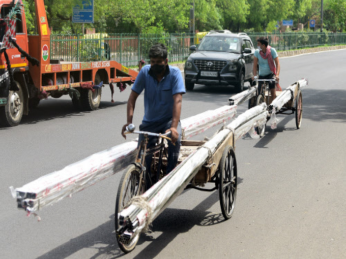 निर्माण कार्य का सामान ले जाता मजदूर